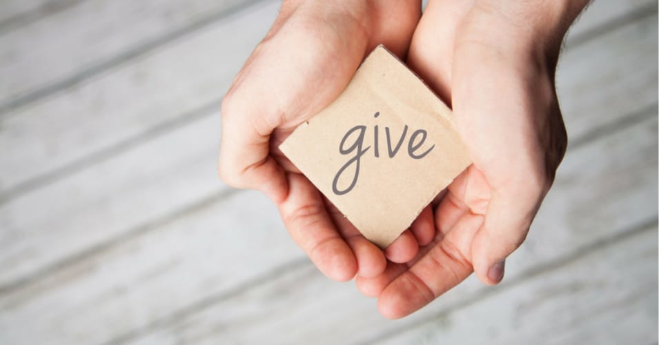 a pair of hands holding a block reading "give"